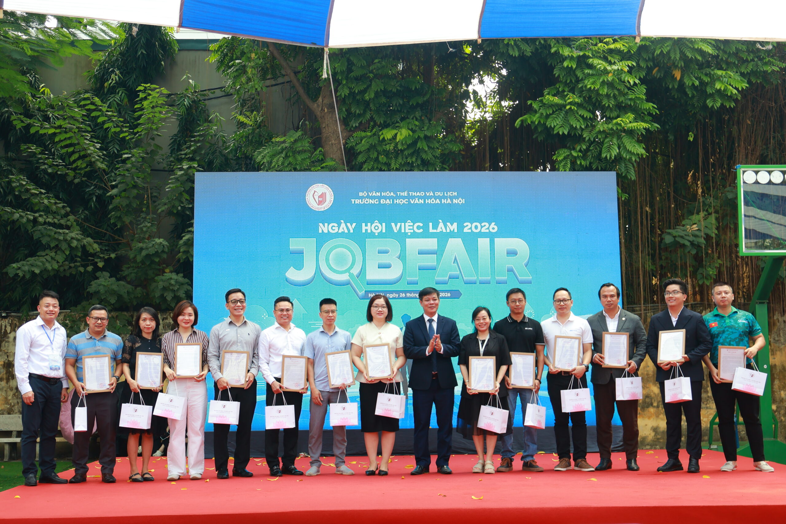 Employers receive letters of appreciation on stage at Job Fair 2026 Hanoi University of Culture