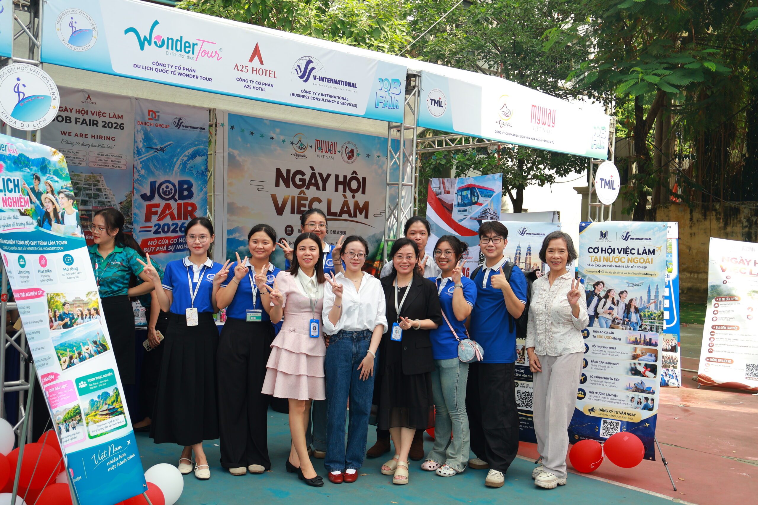 Students and employers pose together at the Faculty of Tourism booth area